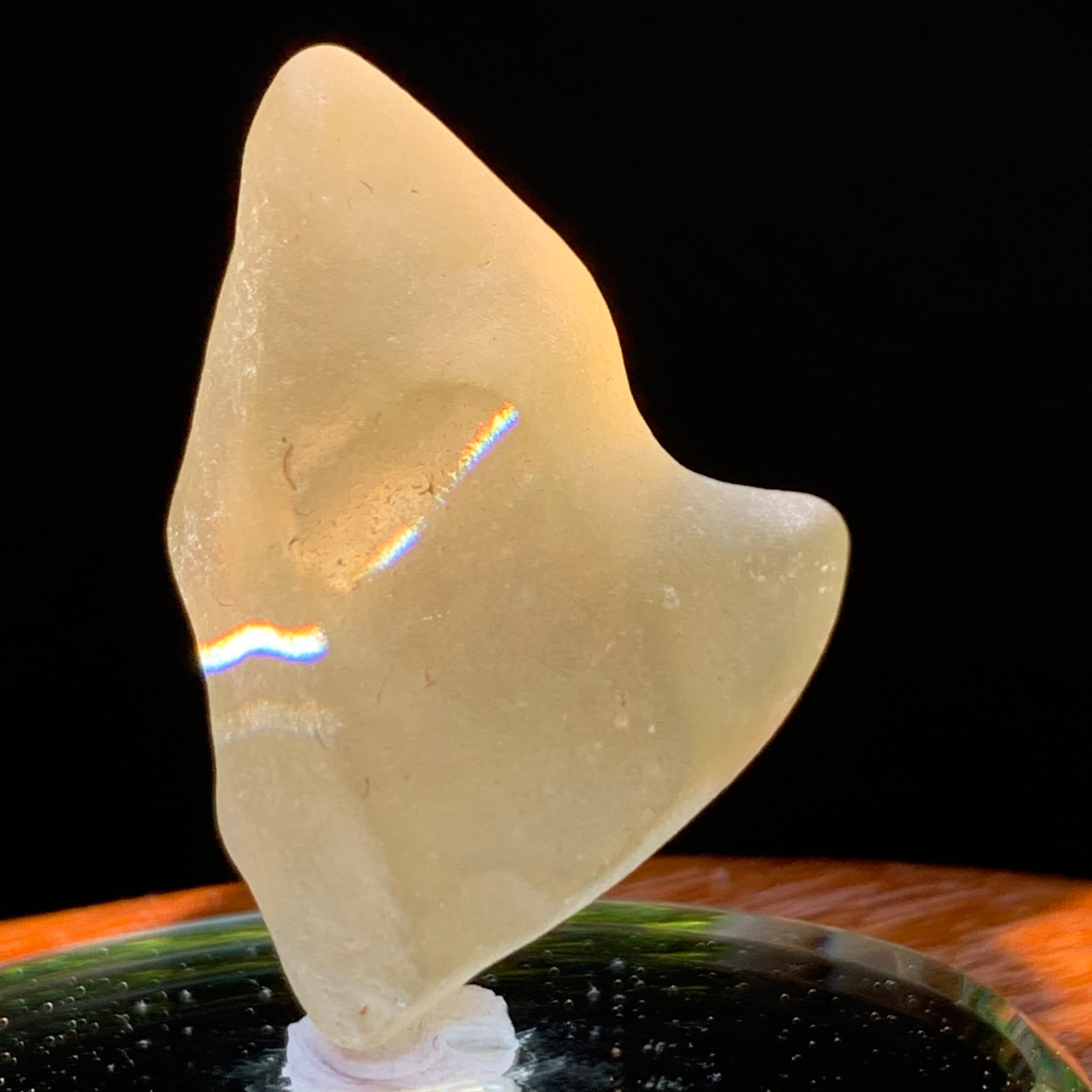 light reflects a rainbow on the libyan desert glass on display