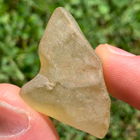 libyan desert glass is held up showing details with sunlight shining on it