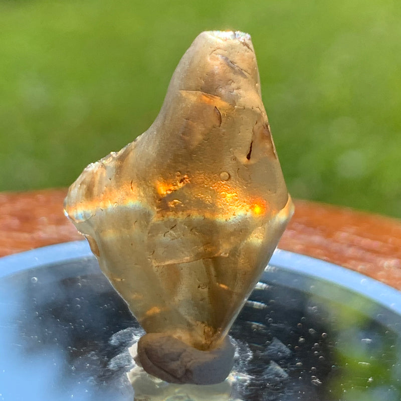 light reflects a rainbow through the libyan desert glass on display