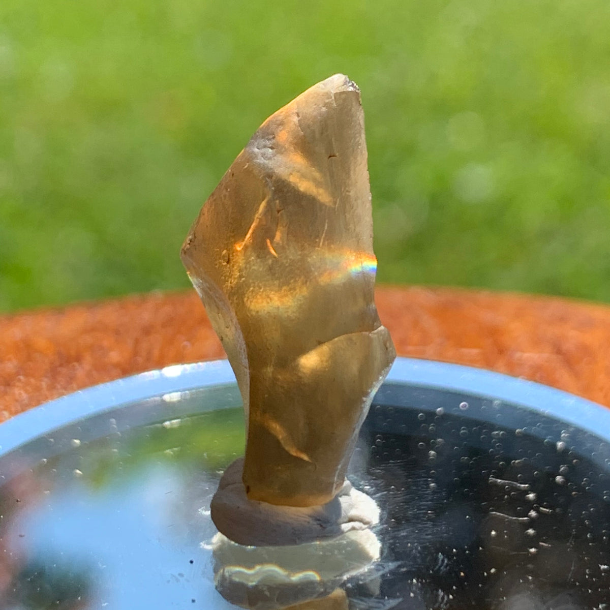 light reflects a rainbow through the libyan desert glass on display