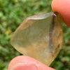 libyan desert glass is held up showing details with sunlight shining on it