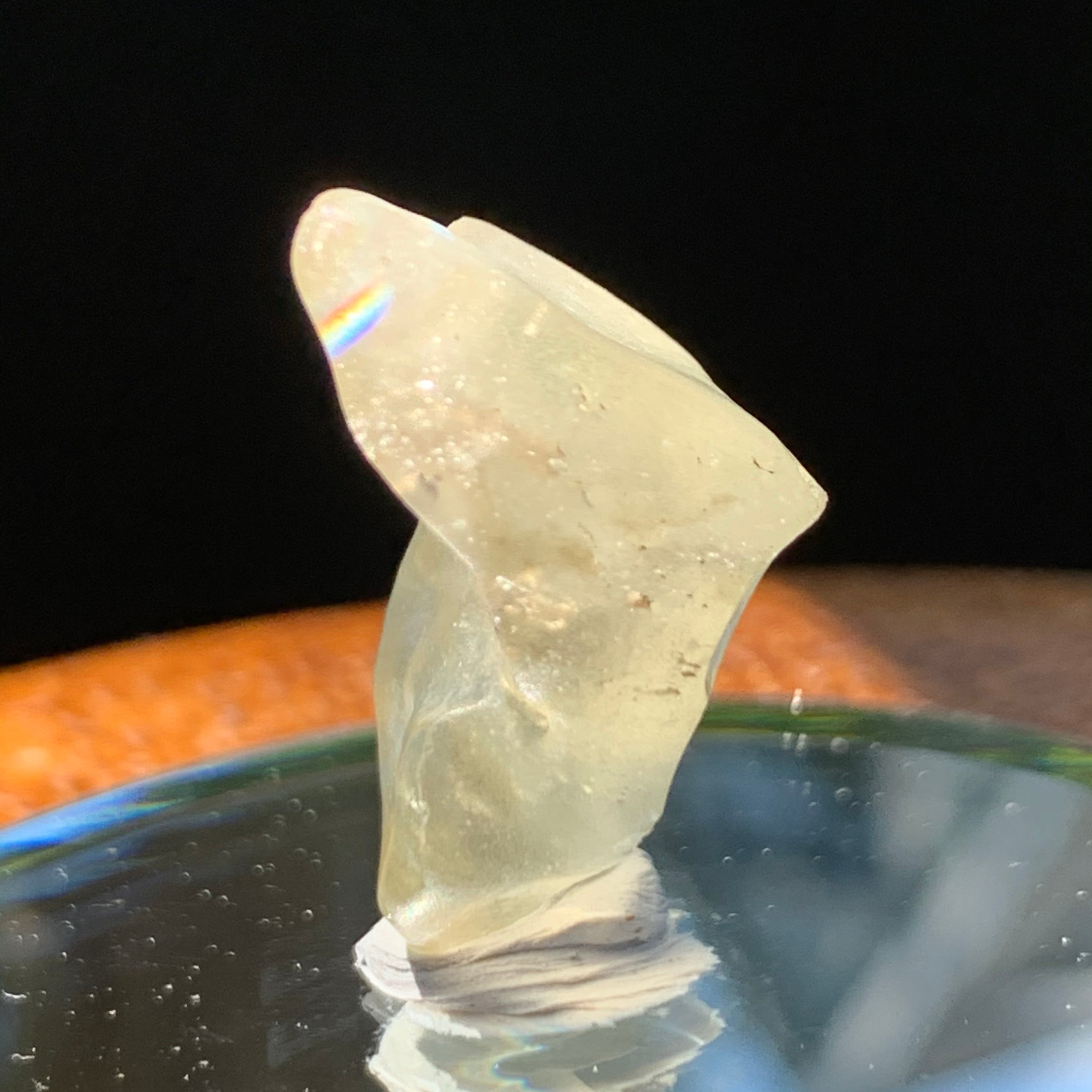 light reflects a rainbow on the libyan desert glass on display