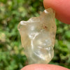 libyan desert glass is held up showing details with sunlight shining on it