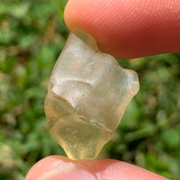 libyan desert glass is held up showing details with sunlight shining on it