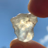 libyan desert glass is held up with sunlight shining through it