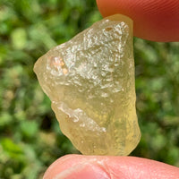 libyan desert glass is held up to show details with sunlight shining on it