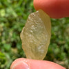 libyan desert glass is held up to show details with sunlight shining on it