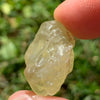 libyan desert glass is held up to show details with sunlight shining on it