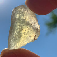 libyan desert glass is held up with sunlight shining through it