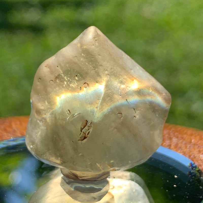 light reflects a rainbow through the libyan desert glass on display