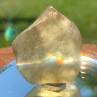 light reflects a rainbow through the libyan desert glass on display