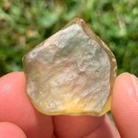 libyan desert glass is held up to show details with sunlight shining on it