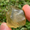 libyan desert glass is held up to show details with sunlight shining on it