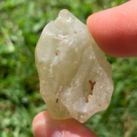 libyan desert glass is held up to show details with sunlight shining on it