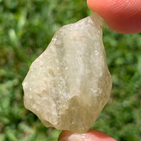 libyan desert glass is held up to show details with sunlight shining on it