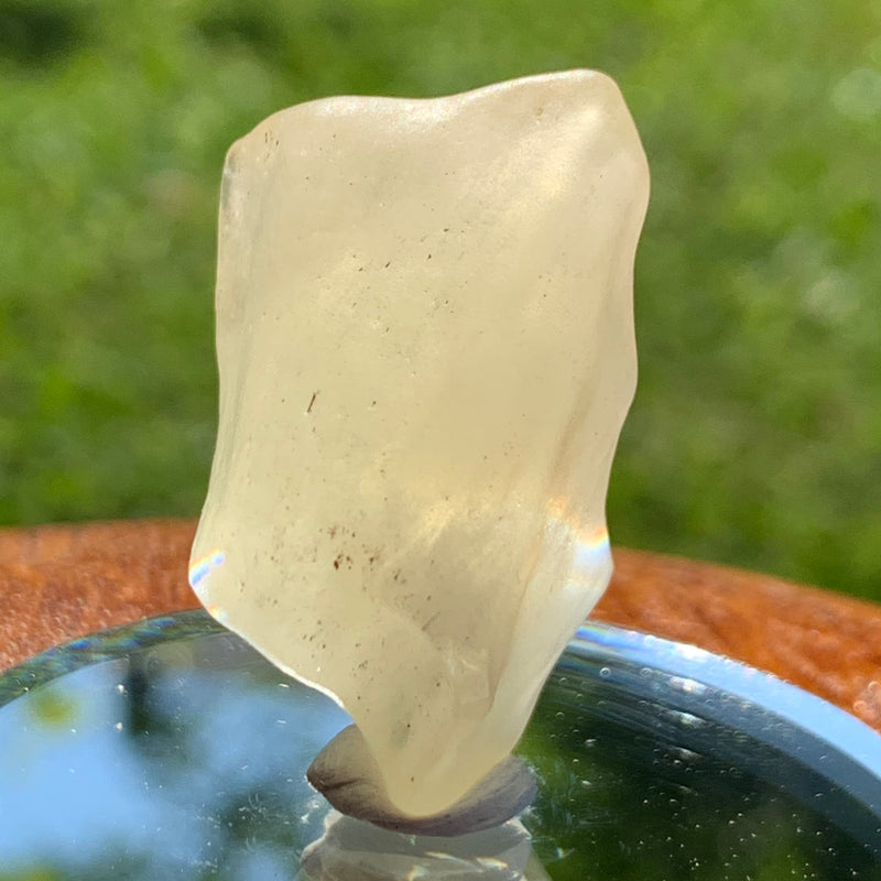 light reflects a rainbow through the libyan desert glass on display