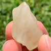 libyan desert glass is held up to show details with sunlight shining on it