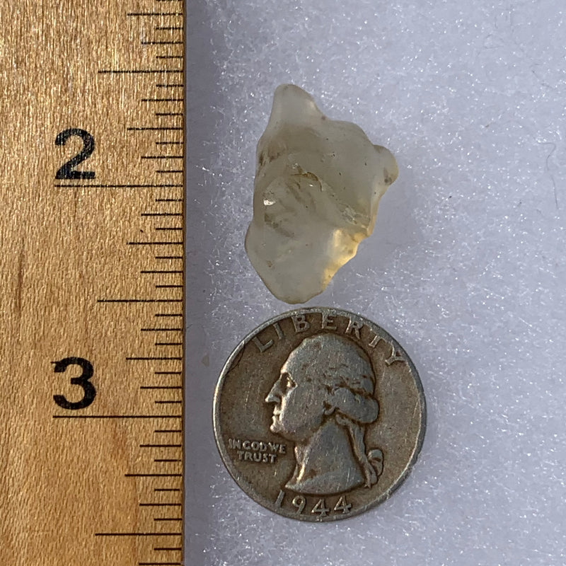 libyan desert glass next to a ruler and US quarter for scale