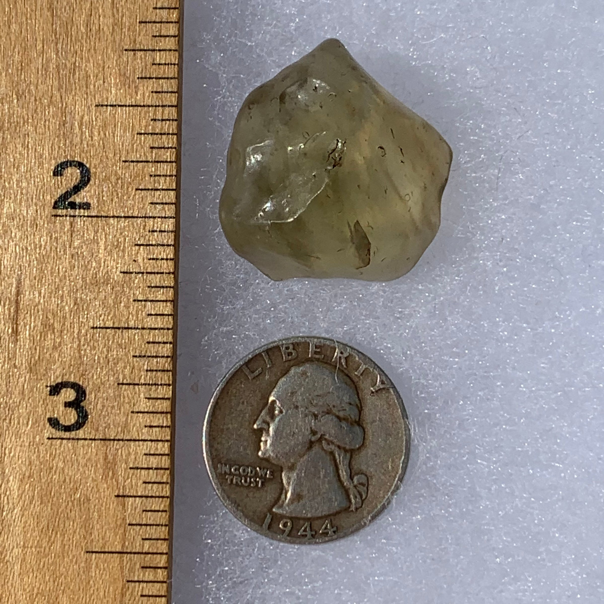 libyan desert glass next to a ruler and US quarter for scale