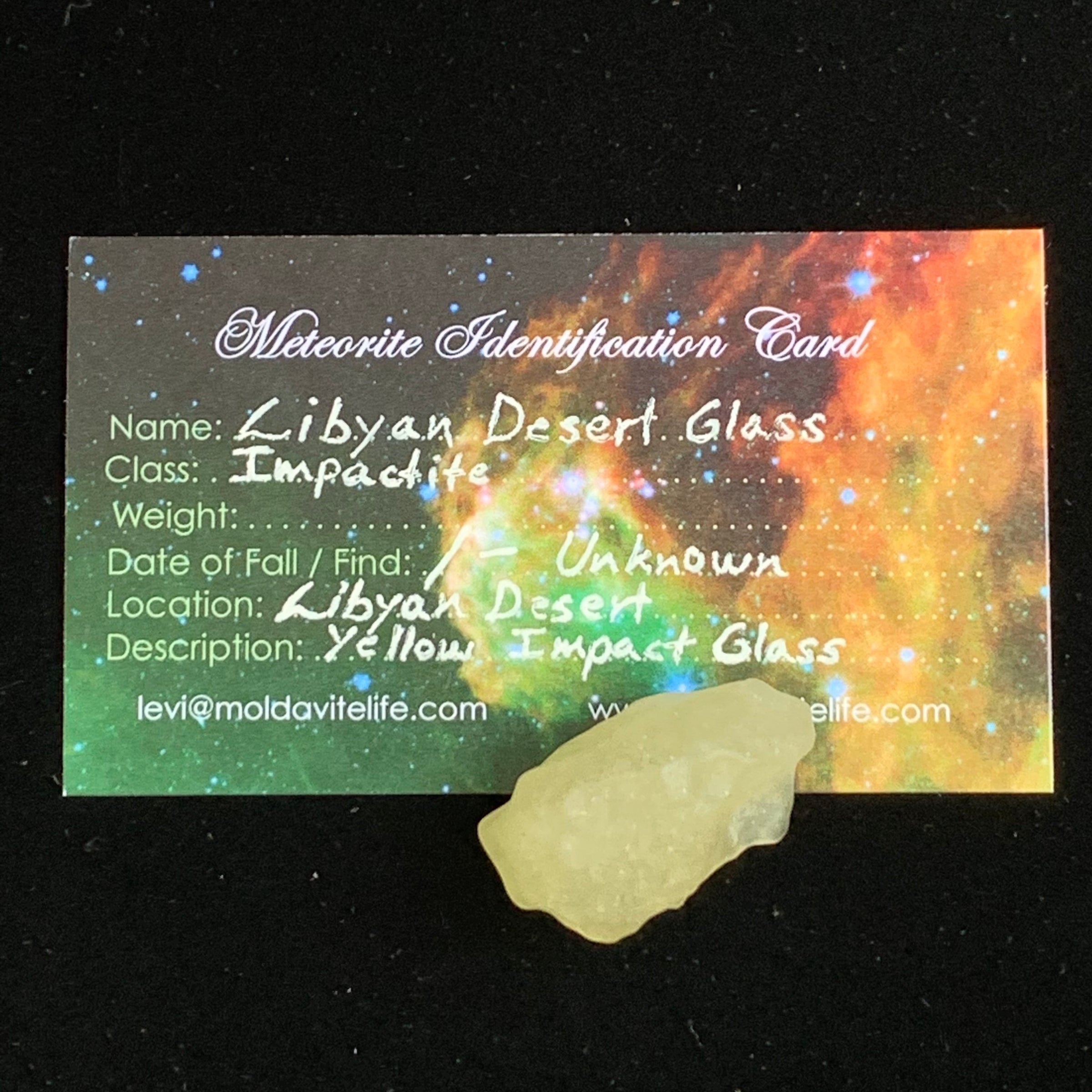 libyan desert glass sits with a moldavite life meteorite identification card