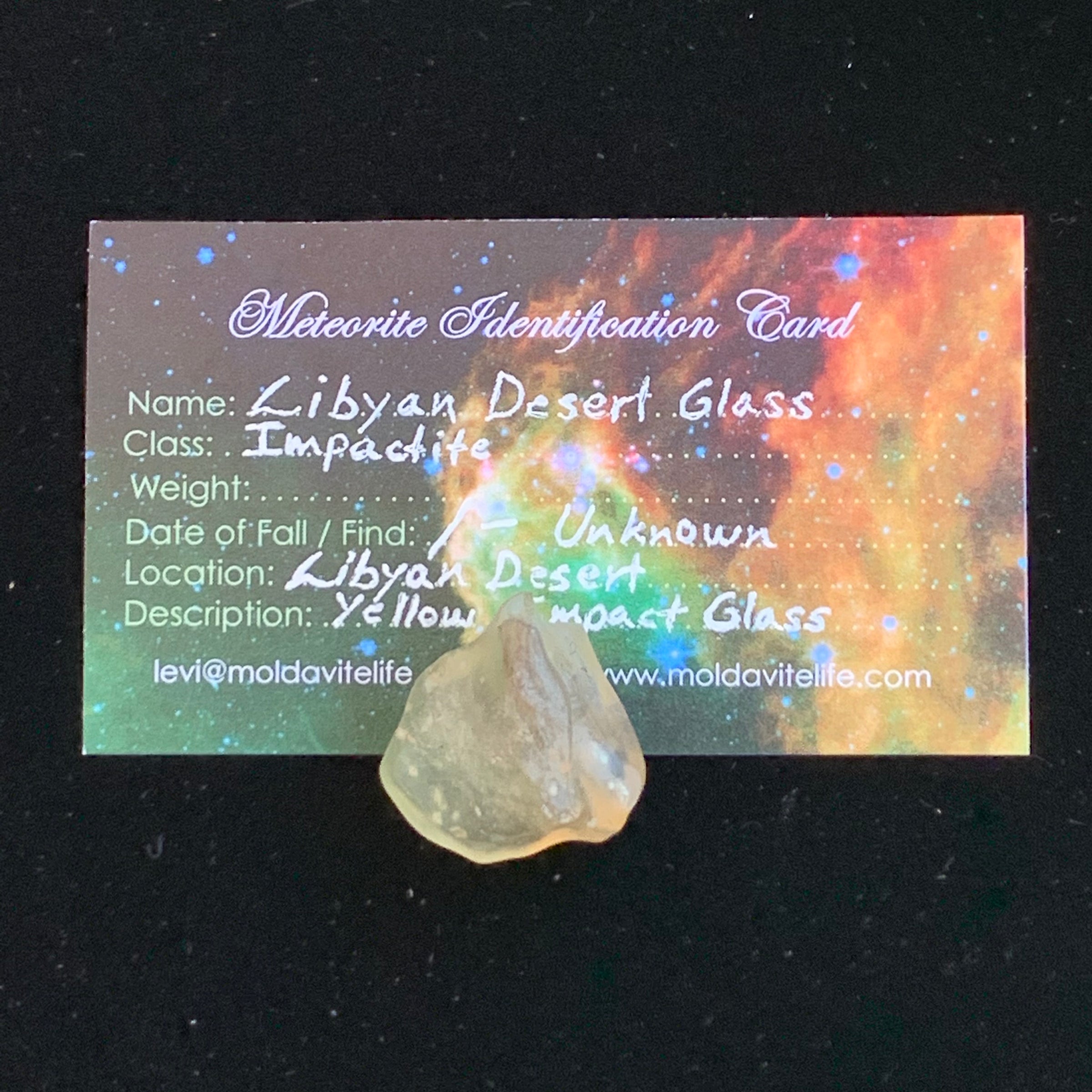 libyan desert glass sits with a moldavite life meteorite identification card