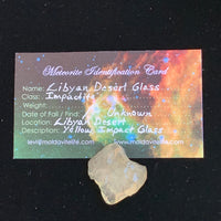 libyan desert glass sits with a moldavite life meteorite identification card