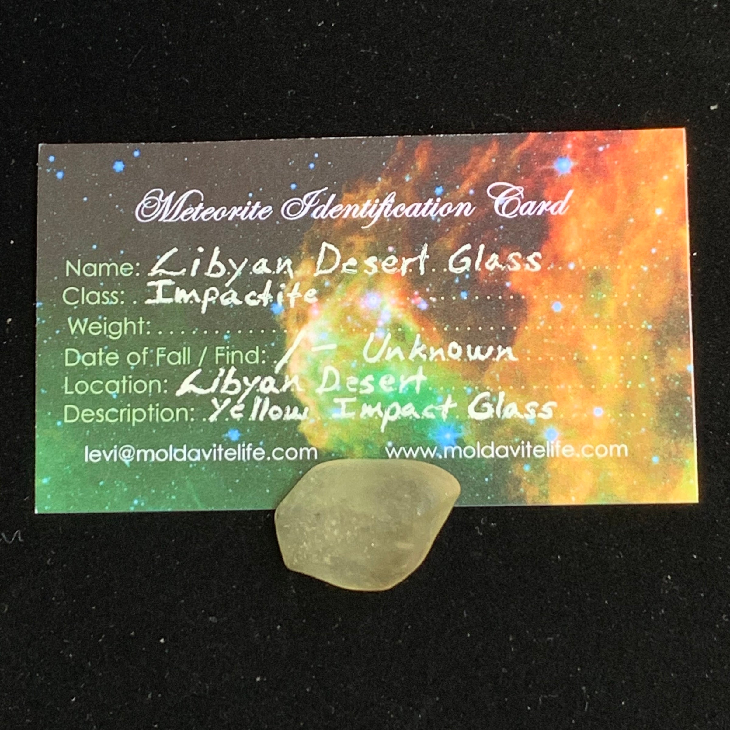 libyan desert glass sits with a moldavite life meteorite identification card