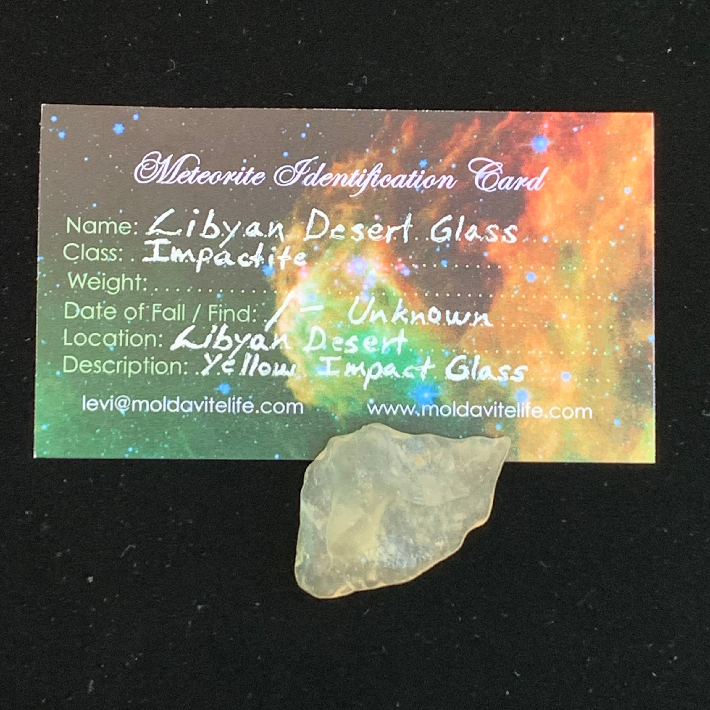 libyan desert glass sits with a moldavite life meteorite identification card