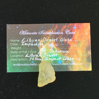 libyan desert glass sits with a moldavite life meteorite identification card