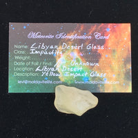 libyan desert glass sits with a moldavite life meteorite identification card