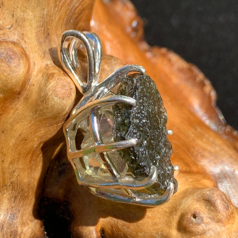 sterling silver moldavite tektite and herkimer diamond basket pendant sitting on driftwood for display
