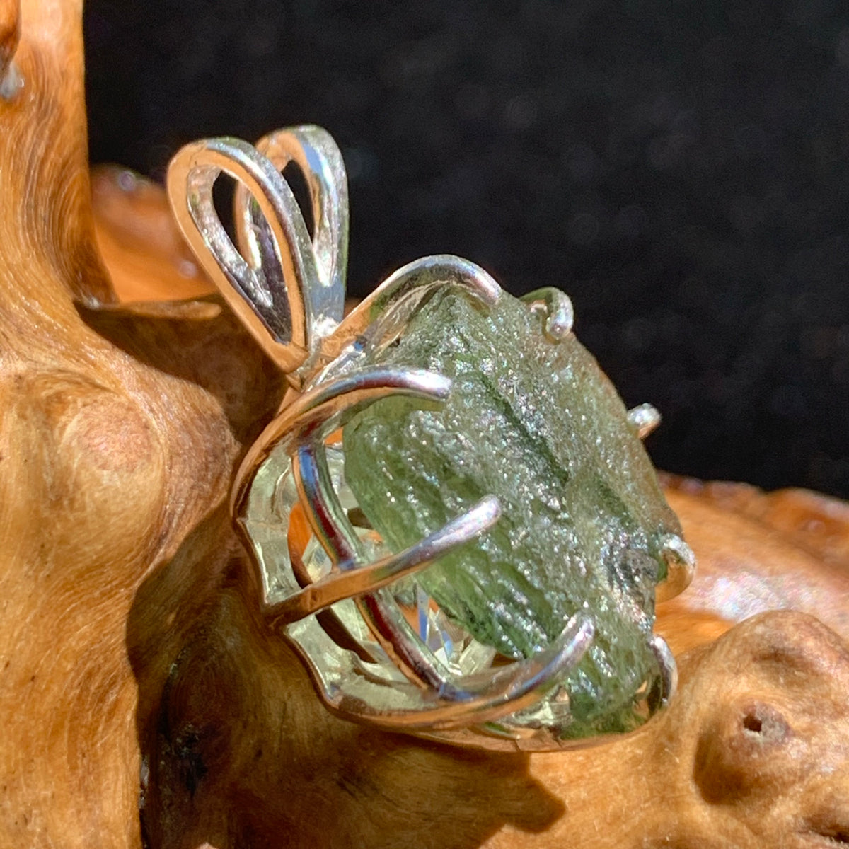 sterling silver moldavite tektite and herkimer diamond basket pendant sitting on driftwood for display