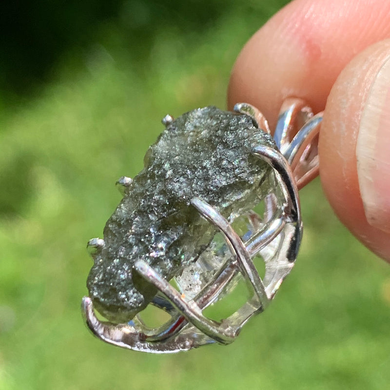sterling silver moldavite tektite and herkimer diamond basket pendant held up on display