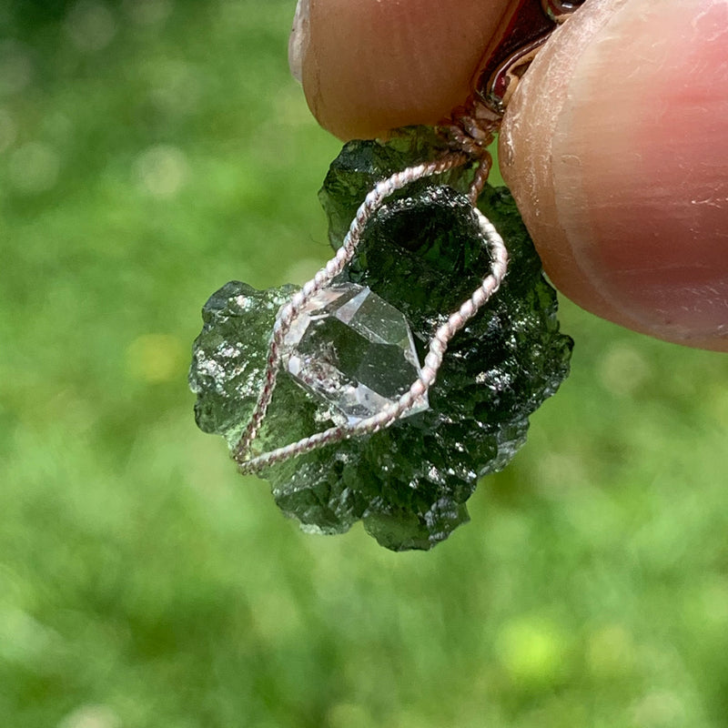 in the sun the moldavite is deeper green and the herkimer shines clearly