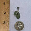 Wire wrapped moldavite pendant next to a ruler and US quarter to show scale