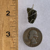 Moldavite sterling silver pendant next to a ruler and quarter