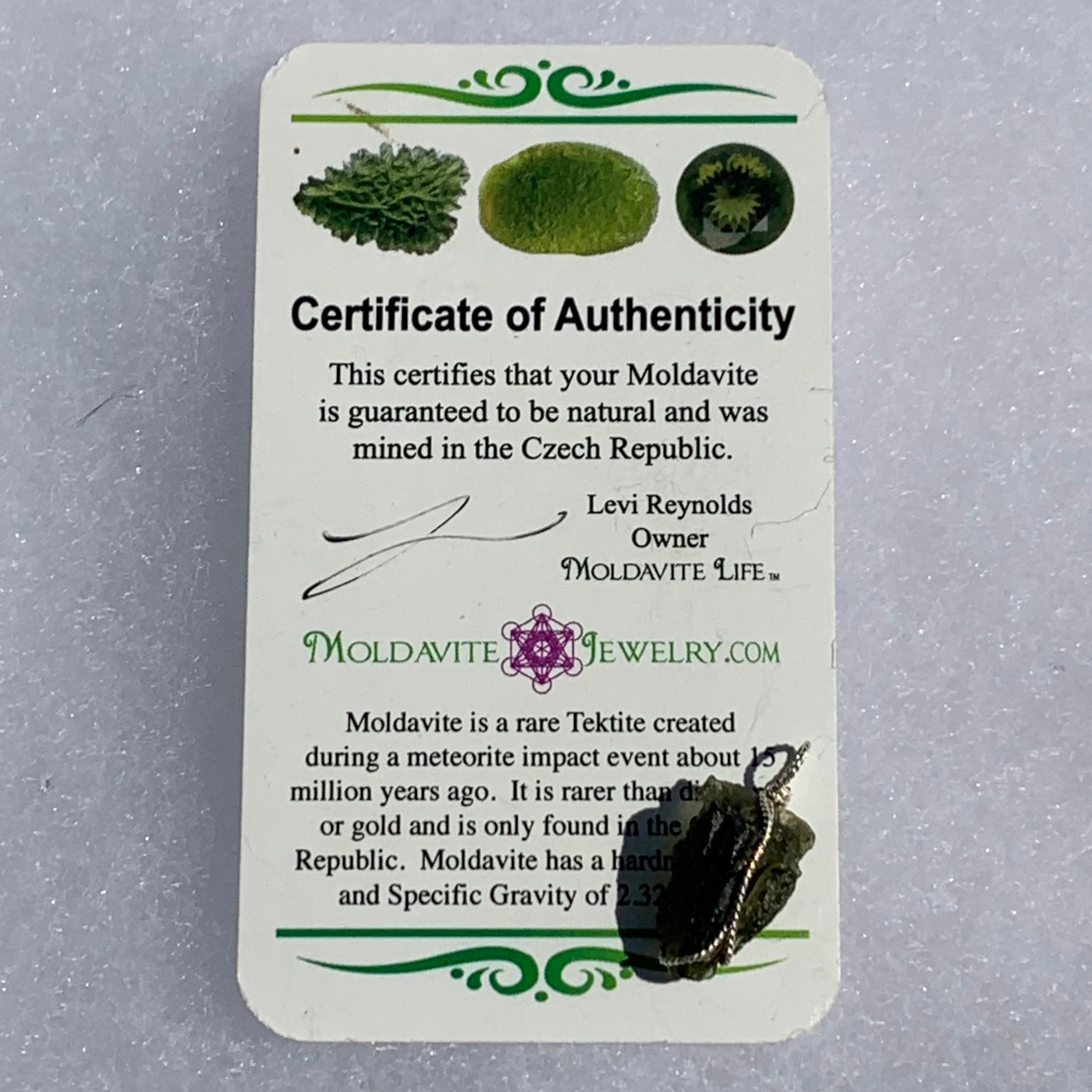 Moldavite sterling silver pendant displayed with the certificate of authenticity