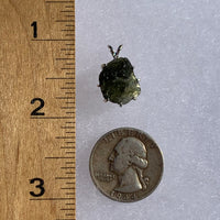 raw moldavite tektite sterling silver basket pendant next to a ruler and US quarter for scale