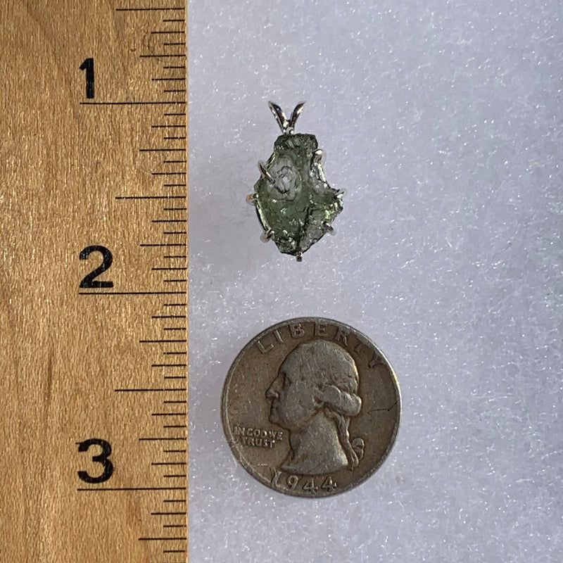raw moldavite tektite sterling silver basket pendant next to a ruler and US quarter for scale