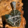 raw moldavite tektite and chlorite quartz crystal sterling silver wire wrapped pendant sitting on driftwood for display