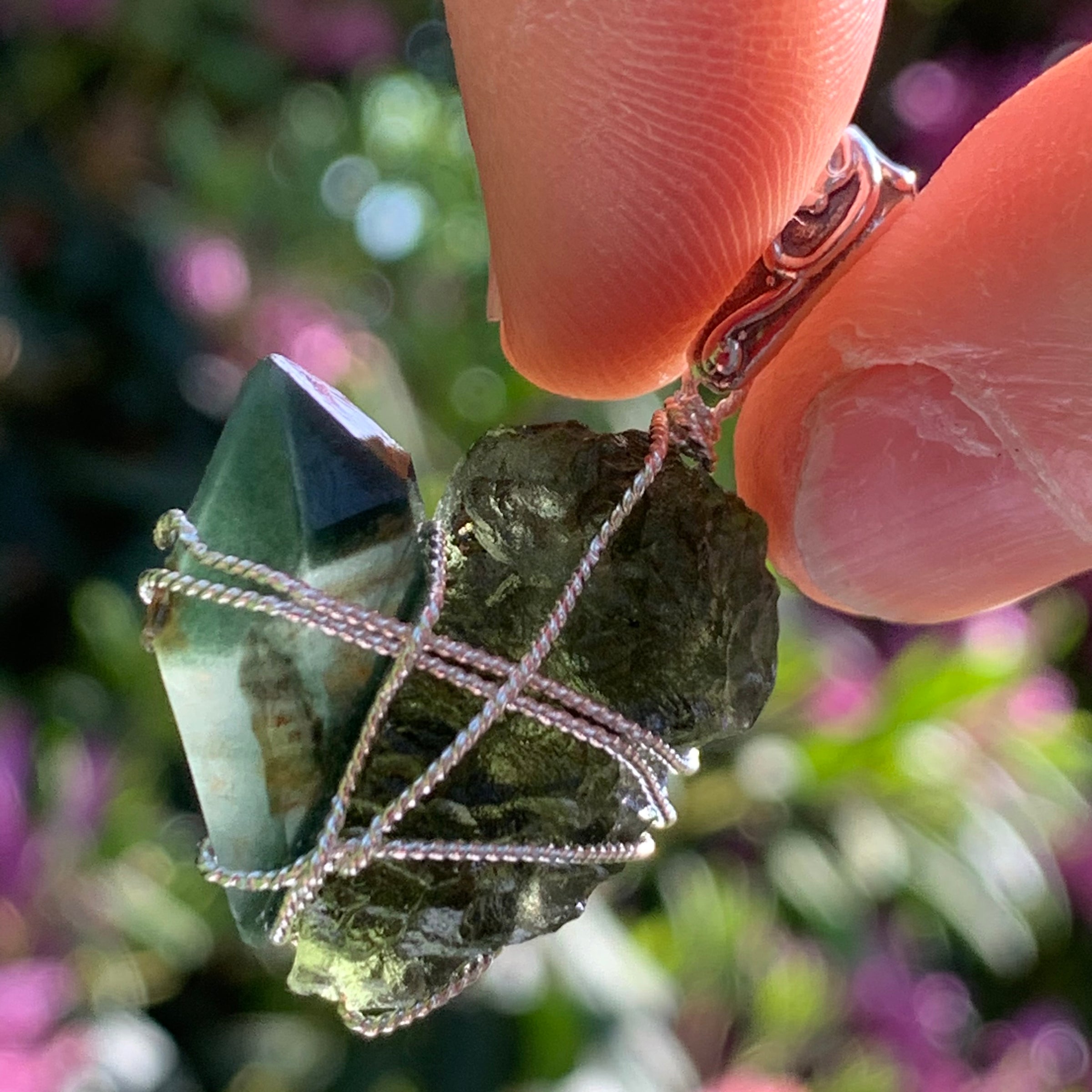 raw moldavite tektite and chlorite quartz crystal sterling silver wire wrapped pendant held up on display to show details