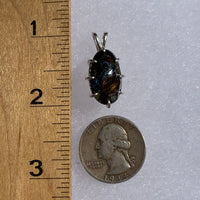 sterling silver sericho pallasite meteorite and raw moldavite tektite basket pendant next to a ruler and US quarter for scale