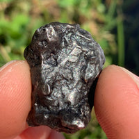 silver sikhote alin meteorite held in hand to show details