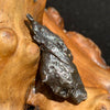 silver sikhote alin meteorite sitting on driftwood for display