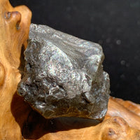 silver sikhote alin meteorite sitting on driftwood for display