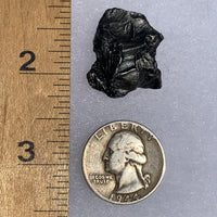 silver sikhote alin meteorite next to a ruler and US quarter for scale