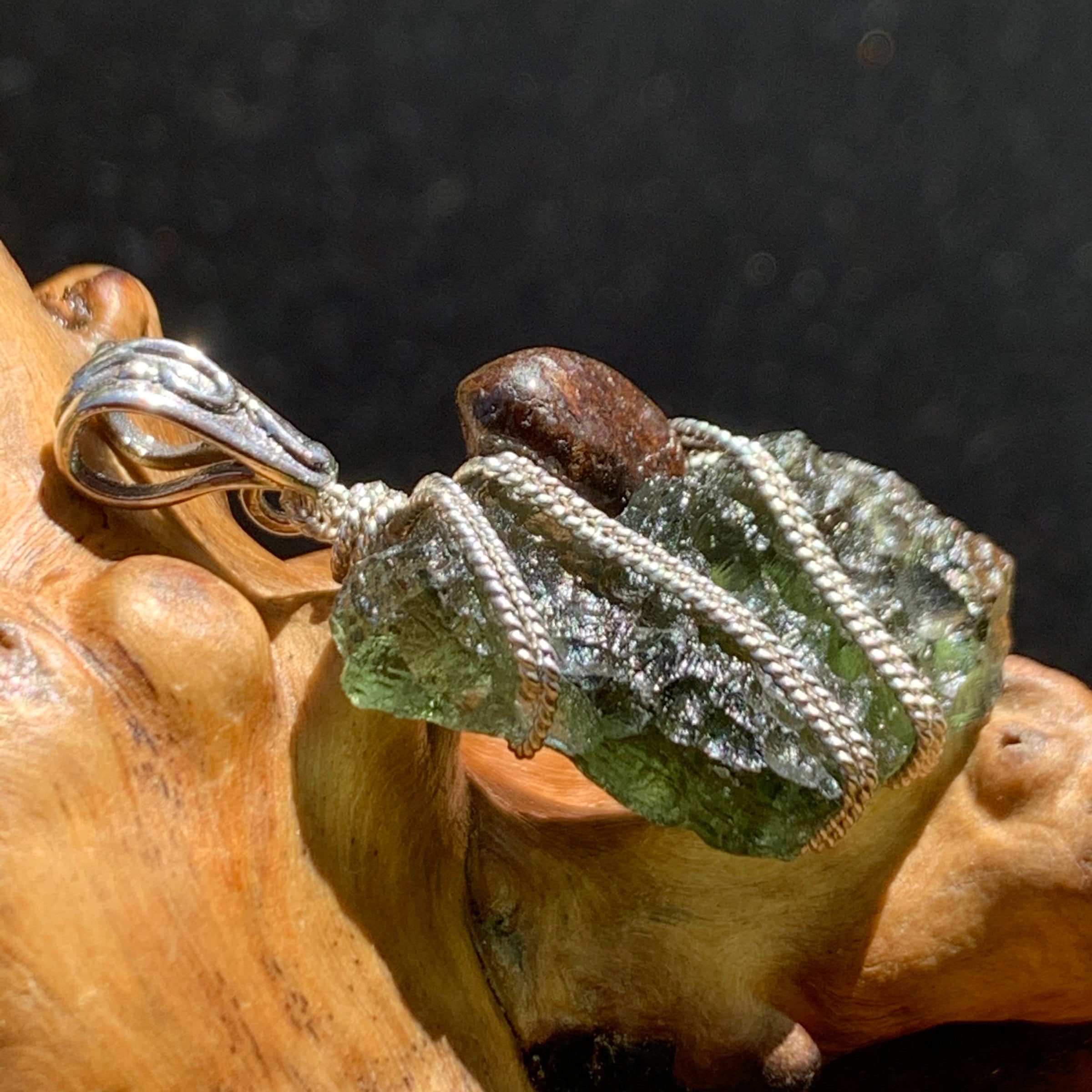 raw moldavite tektite and nwa 869 meteorite bead sterling silver wire wrapped pendant sitting on driftwood for display