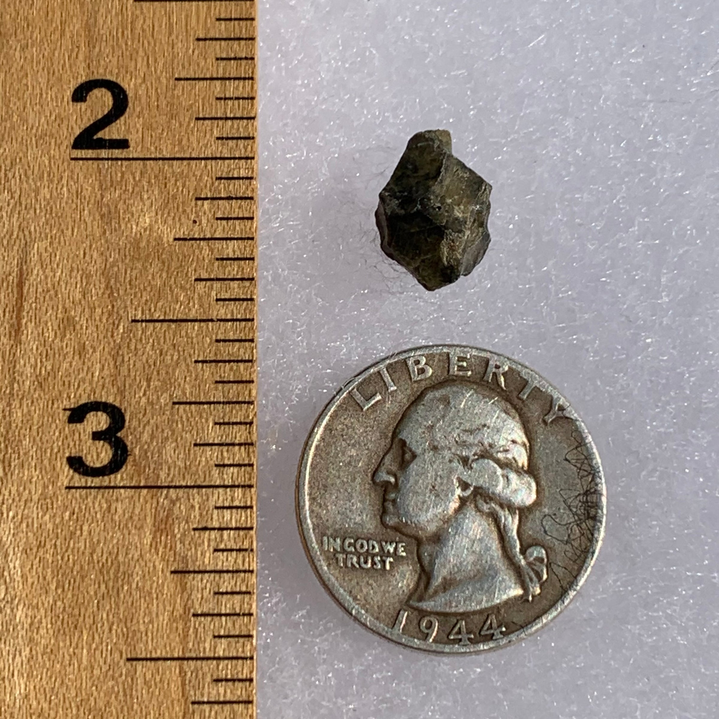 tatahouine meteorite next to a ruler and US quarter for scale