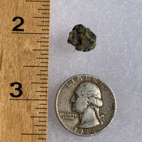 tatahouine meteorite next to a ruler and US quarter for scale