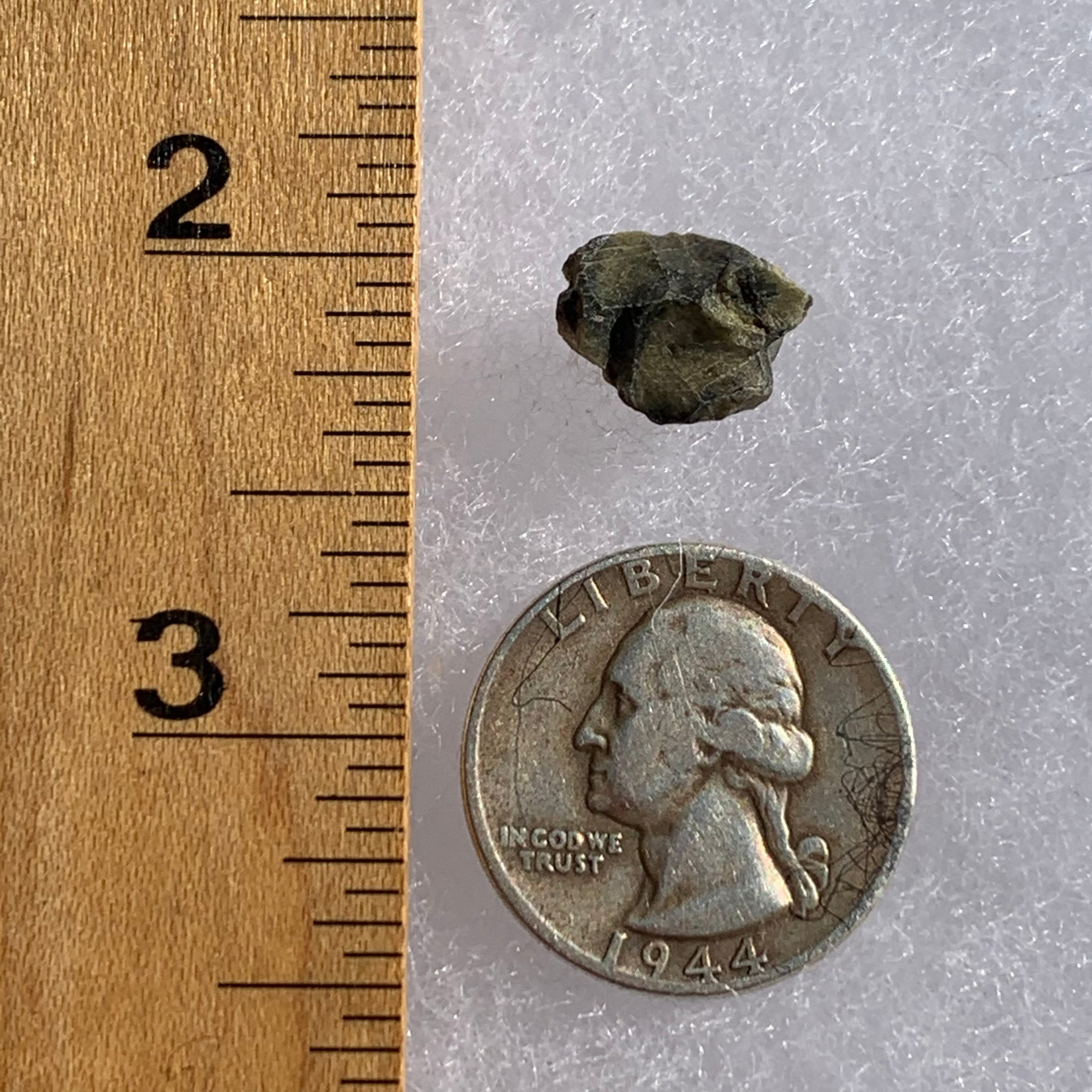 tatahouine meteorite next to a ruler and US quarter for scale